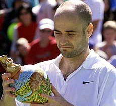 Andre Agassi from the USA smiles as he holds his runner-up trophy in the final of the Kooyong Classic Tennis Tournament in Melbourne on Saturday. 