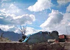 AFTERNOON SIESTA: Clouds hovering overhead, a man uses a roadside parapet to doze off for a while in the momentary sunshine near Parwanoo on Thursday.