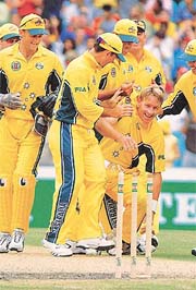Australian bowler Andy Bichel (R) is congratulated by team-mates