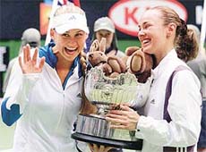 Martina Hingis from Switzerland, right, and her doubles partner Russia's Anna Kournikova hold the winners trophy