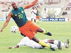 Cameroon's defender Mboma Dem Parick Henri falls under a tackle from Togo's Akoto Eric.