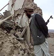 A Northern Alliance soldier looks at the ruins of a house in the village of Aawbazak, some 45 km south of Kabul on Thursday. 