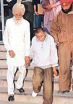 13-year-old Jaswinder being led away by his grandfather, Teja Singh, from the Child Help Line Centre in Sector 17, Chandigarh, on Friday.