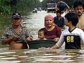 An Indonesian couple, with their child in a floating bucket