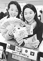 Japanese tourists travelling to Europe show bills of the new European currency, Euro, prior to their departure at Kansai International Airport in Izumisano, western Japan.