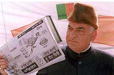 Senior BJP leader Madan Lal Khurana showing an advertisement released by the Congress that he said was objectionable
