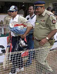 India's Sachin Tendulkar (L), escorted by Indian policemen