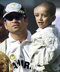 India's Sachin Tendulkar holds a child suffering from cancer 