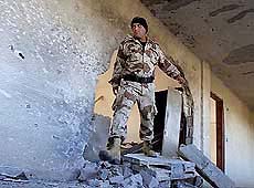 Palestinian naval policeman inspects damage to the naval headquarters 