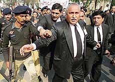 A policeman attempts to stop Pakistani lawyers from holding a protest against a new decree issued by President Pervez Musharraf in Lahore