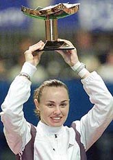 Martina Hingis of Switzerland smiles as she raises the trophy after defeating Monica Seles of the USA to win the Pan Pacific Open