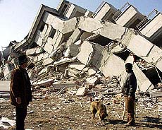 Residents look at the wreckage of their collapsed houses