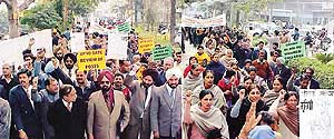 College teachers hold protest rally in Ludhiana on Thursday.