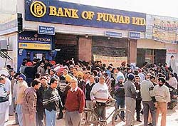 Panicky customers queue outside an ATM counter of the Bank of Punjab in Sector 9 on Friday to withdraw cash.