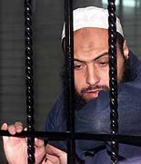 American-born Jordanian Islamist Raed Hijazi looks down in disbelief in a Jordanian state security court in Amman on Monday