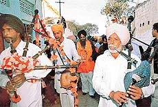 Bagpipers lead a procession of the SAD candidate from Kharar, Mr Kiran Bir Singh Kang, in Mauli Baidwan village, near SAS Nagar, on Monday.