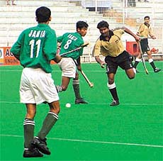 Players of J.M.I. Delhi(Green)and N.A.S. College, Meerut (Yellow), in action in the final of the 9th Nehru -ONGC College Hockey
