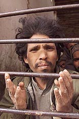 A Pakistani Taliban prisoner peers from behind bars at Shiberghan prison