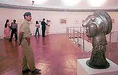 A security person watches over a sculpture by legendary painter and sculptor Pablo Picasso 