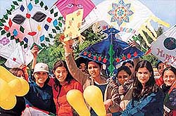 Enthused girls usher in the spring by holding out vibrant kites
