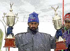 Muzaffar Ahmad (L), a Kashmiri skier, holds aloft two first prize trophies