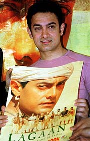 Indian actor Aamir Khan poses with a copy of film-based comic of his Hindi film "Lagaan"