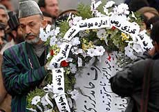 Afghan interim leader Hamid Karzai lays a wreath