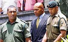 Failed Fijian coup leader George Speight is led by policemen out of a Suva court 