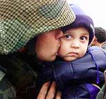 A Bulgarian army soldier kisses his child