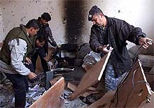 Palestinian policemen inspect damage to the office of the Islamic militant group Hamas 