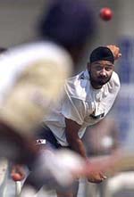 Indian spinner Harbhajan Singh bowls to a teammate