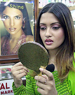 Indian model and upcoming Bollywood star Ria Sen looks at herself in a mirror.