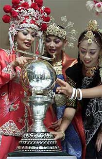 Traditionally clad Malaysian women look at the hockey World Cup trophy