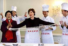 US First Lady Laura Bush tries making Chinese noodles during a cooking demonstration by chefs at the US Embassy in Beijing on Thursday.