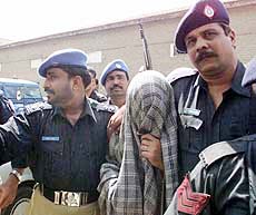 Pakistani policemen escort a suspect in the kidnapping case of US reporter Daniel Pearl