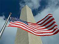 The Washington Monument is seen with an American flag flying in the foreground in Washington. 
