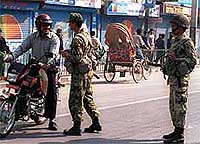 A scooterist talks to an armyman on a street in Katmandu on Saturday