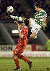Celtic's Paul Lambert, right, leaps to take the ball