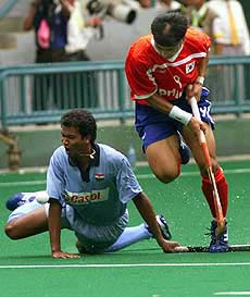 Lajrus Barla of India falls down on the ground as he vies for the ball