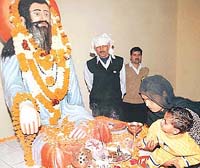 A woman and her child pay obeisance to the Guru, on Guru Ravidas birthday, in Karsan Colony, Ram Darbar, Chandigarh, on Wednesday.