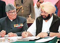 The newly elected Chief Minister of Punjab, Capt Amarinder Singh, signs the papers after the oath ceremony at Punjab Raj Bhavan in Chandigarh on Wednesday.
