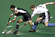 Pakistan's Muhammad Shabir dribbles past New Zealand's Simon Towns