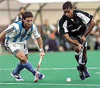 Pakistan's Ahmed Shahbaz dribbles past Argentina's Rodrigo Vila