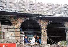 Three Muslim students look from the first floor of Jama Masjid in Field Ganj, Ludhiana, on Friday.