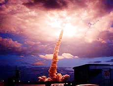 Space shuttle Columbia flies into a cloudbank which it illuminated after liftoff at the Kennedy Space Center in Florida on Friday