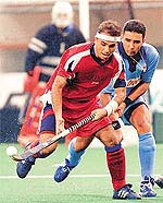 Cuba's Roberto Rodriguez (L) shields the ball from India's Deepak Thakur 