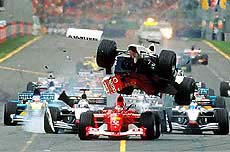 The Williams of Ralf Schumacher of Germany, center, climbs over the Ferrari of Brazil's Rubens Barrichello