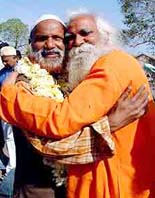 A sadhu embraces a Haj pilgrim