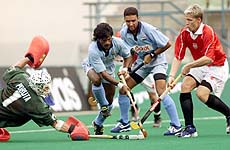 India's Dhanraj Pillay tries to beat Poland's goalkeeper