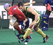 Australia's Jamie Dwyer (R) tries to get past South Korea's Kim Jung-Chui